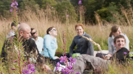 flowers in foreground with people smiling and laughing in background