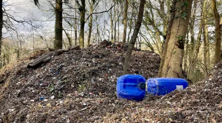 Hoad's wood fly tipping pile with blue plastic containers in foreground