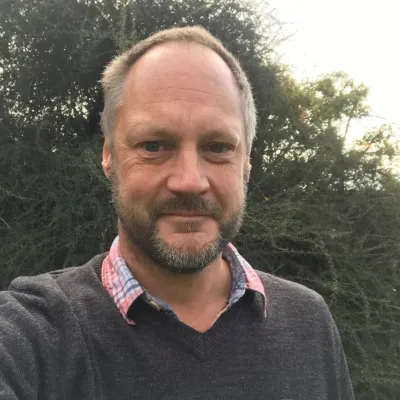 Simon Bateman-Brown, Acting Deputy Director (Land Mangement) at KWT, smiling in front of a woodland backdrop.