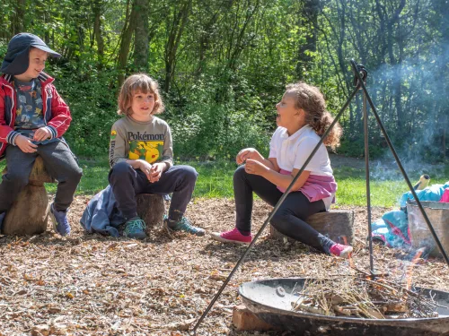 children gathered around campfire laughing